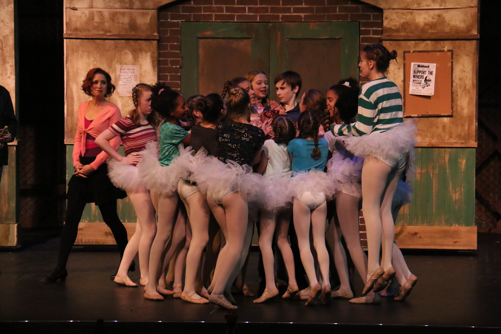 Ballet dancers crowd around Billy Elliot (Pete Pierantozzi) to find out if he got into the dance school.